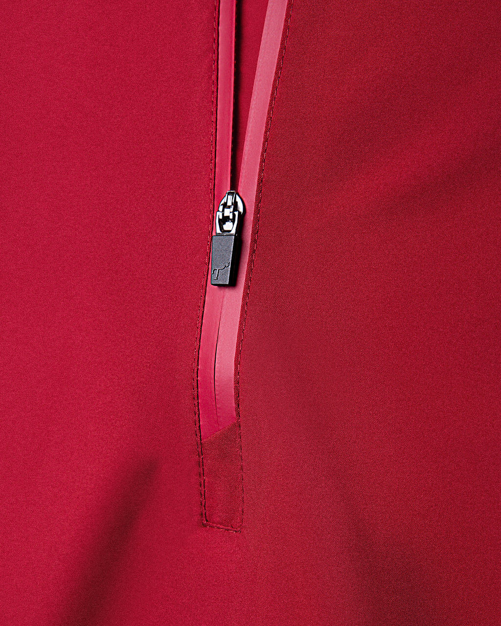 Close-up of a red zipper on a red fabric background