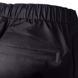 Close-up of black pants with a focus on the waistband and fabric texture.